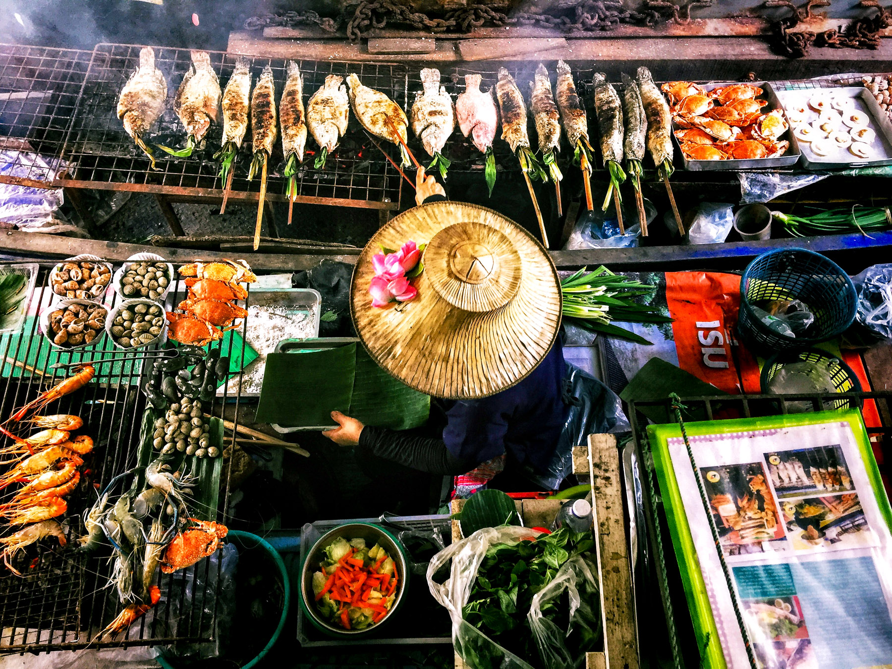 Aerial view of a lady working the food stall at a street food market in Bangkok