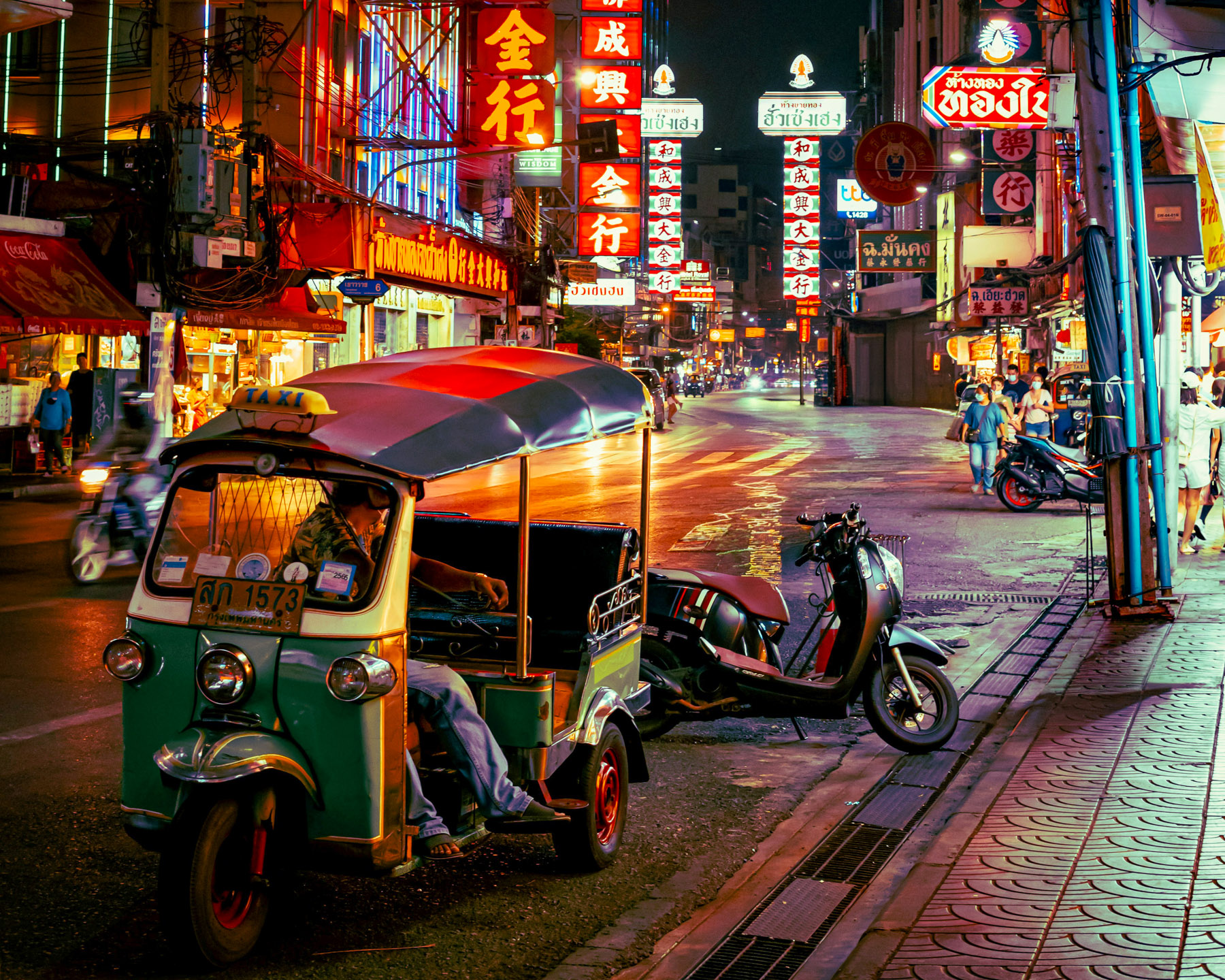 Tuk tuks parked on the road at night in Bangkok