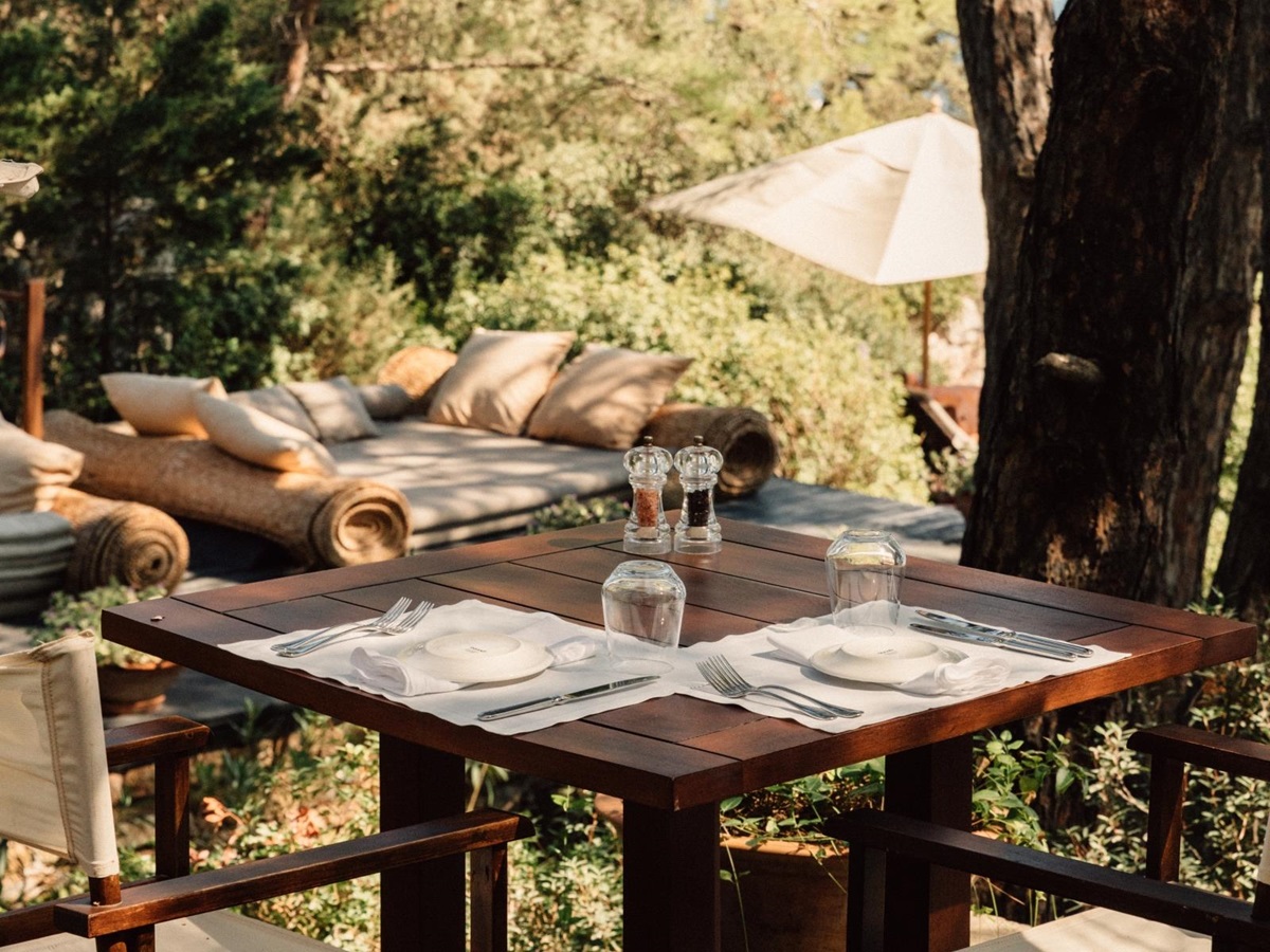 Tree shaded dining terrace of the beach club at luxury hotel Amanruya, Turkey