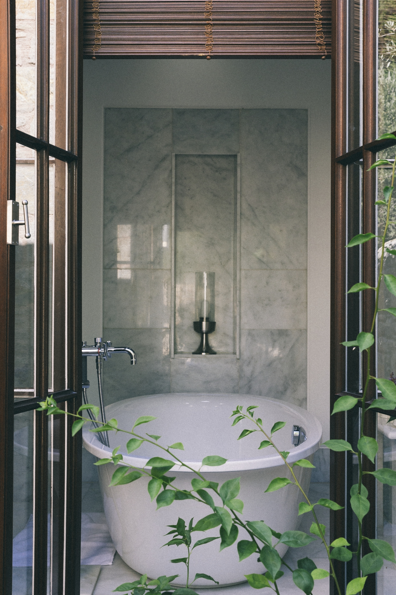 View through an open window onto a luxurious bathtub in a marble bathroom at luxury hotel Amanruya, Turkey