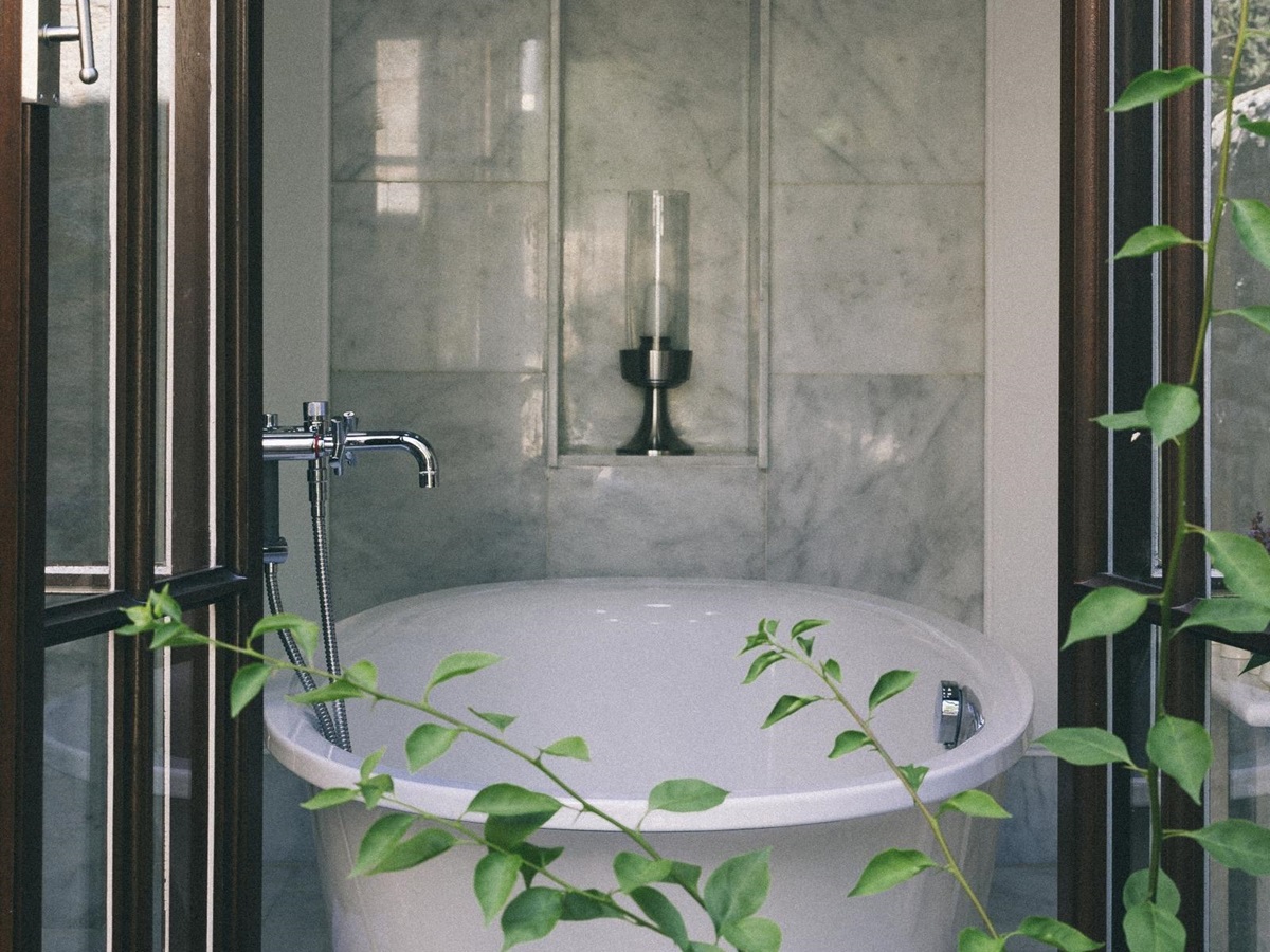View through an open window onto a luxurious bathtub in a marble bathroom at luxury hotel Amanruya, Turkey