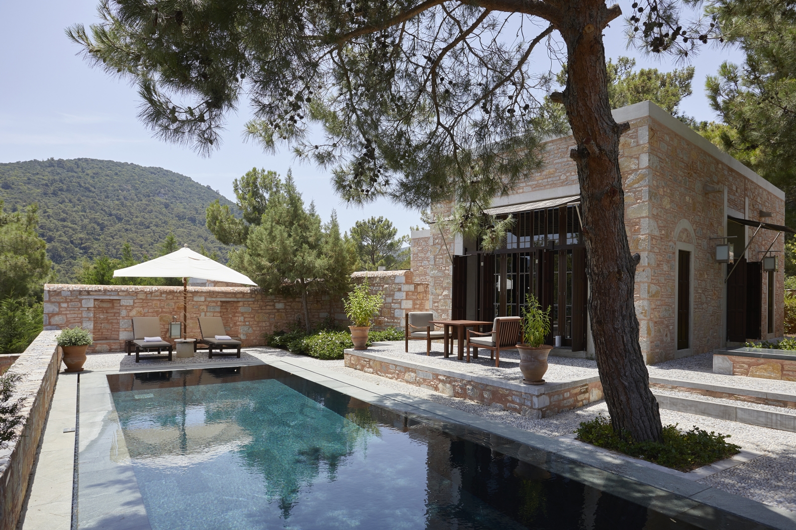 Exterior of a Garden View Pool Pavilion at luxury hotel Amanruya, Turkey, with terrace seating and loungers by the pool