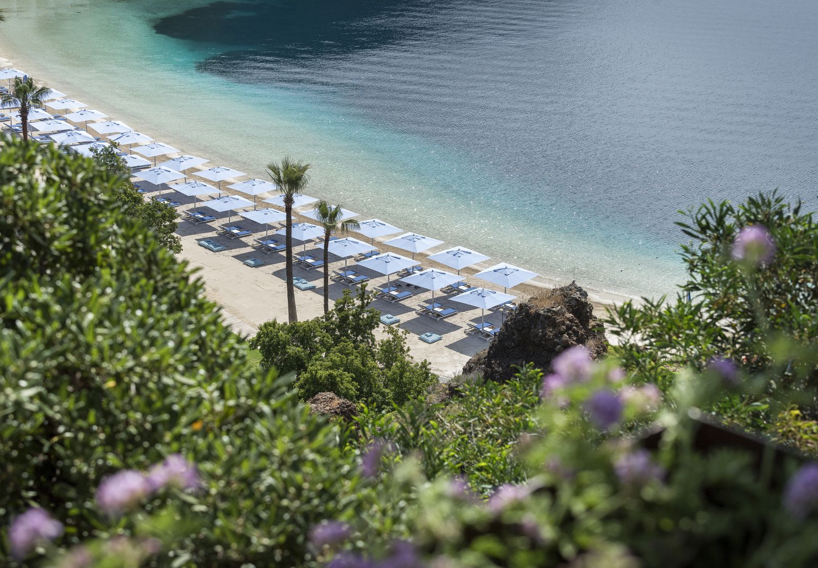 The bay beach at luxury resort D-Maris Bay in Turkey with sun loungers and parasols