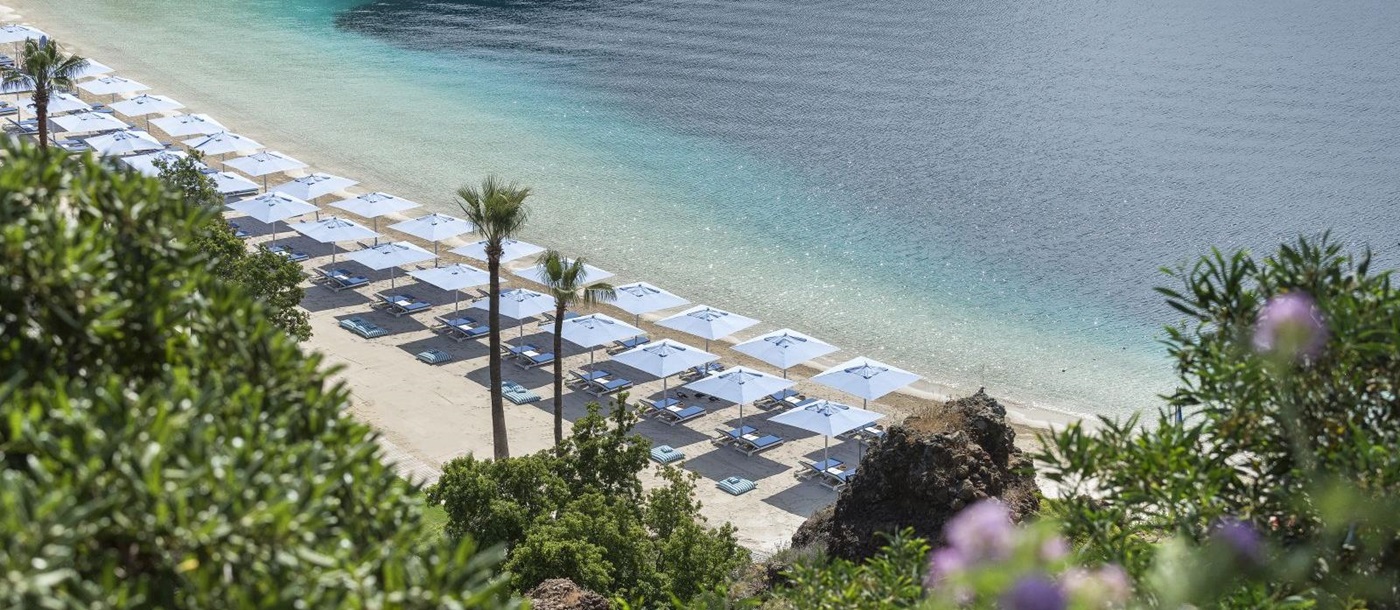 The bay beach at luxury resort D-Maris Bay in Turkey with sun loungers and parasols