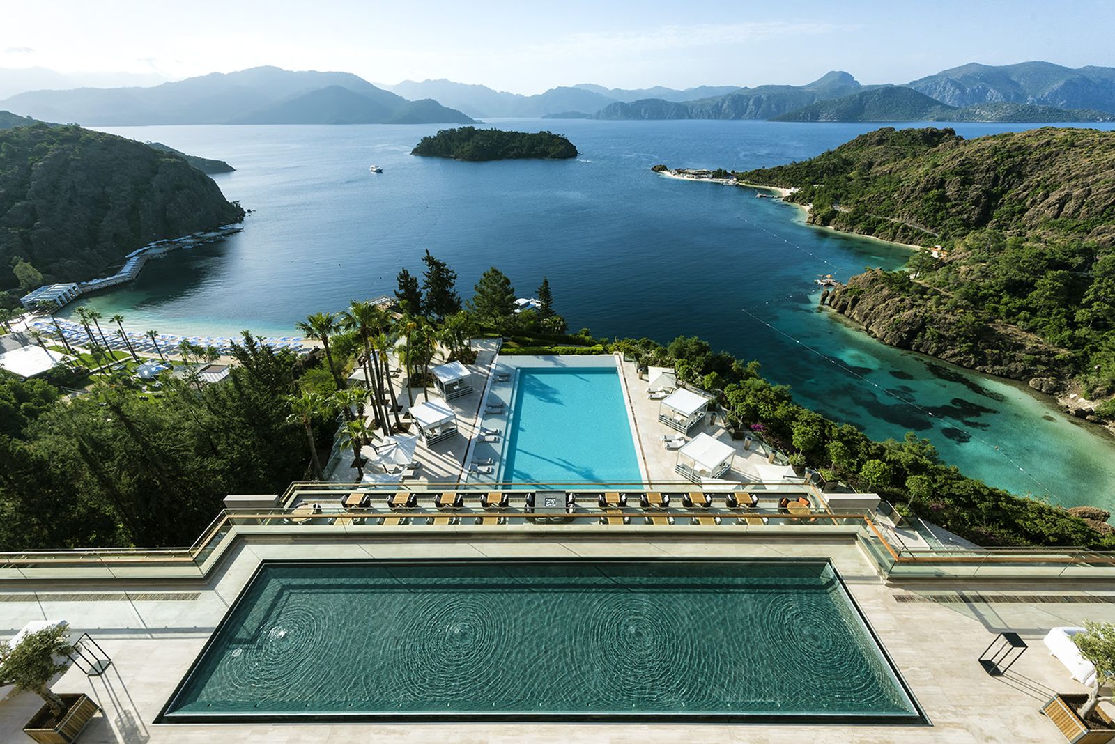 View over two pools and beaches with sun loungers and cabanas at luxury resort D-Maris Bay in Turkey