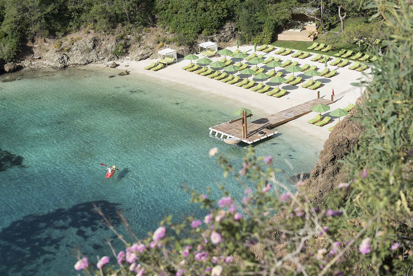 Guest kayaking in the turquoise waters in front of a beach at luxury resort D-Maris Bay in Turkey