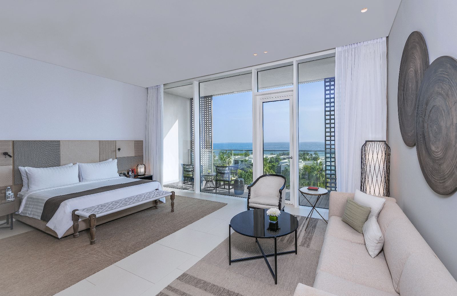 Bedroom of a Deluxe Suite with private balcony at luxury beach resort The Oberoi Al Zorah in the United Arab Emirates