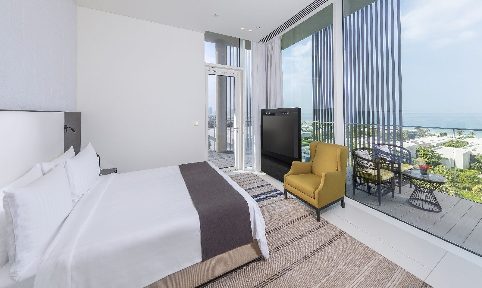 Bedroom of a Kohinoor Suite with private balcony at luxury beach resort The Oberoi Al Zorah in the United Arab Emirates