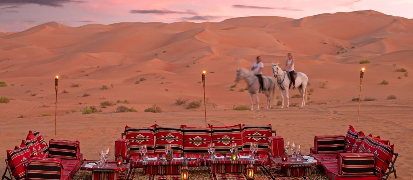 Guests arriving on horseback to desert picnic at the Anantara Qasr al Sarab in Abu Dhabi