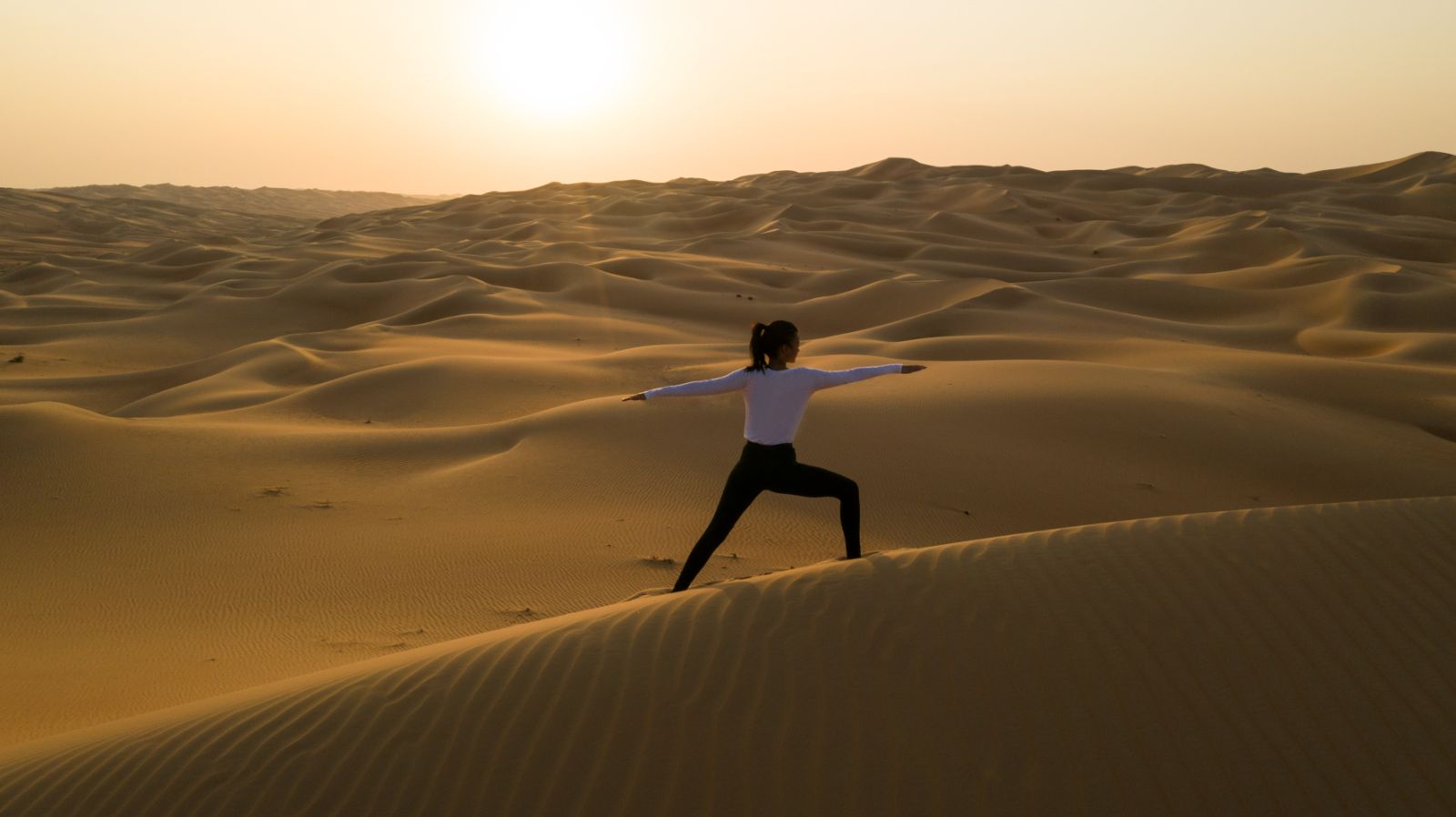 Lady practicing yoga in the desert at Qasr al Sarab by Anantara in Abu Dhabi