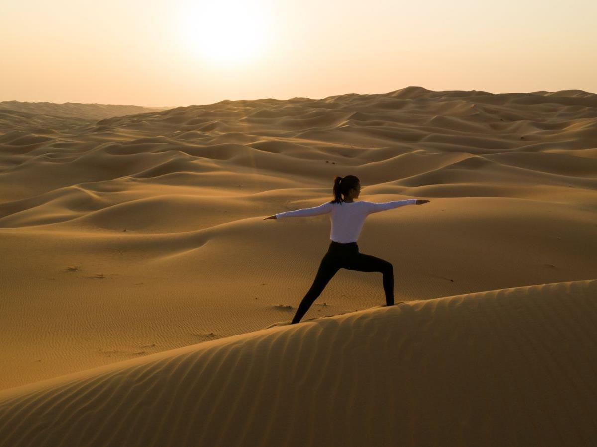 Lady practicing yoga in the desert at Qasr al Sarab by Anantara in Abu Dhabi