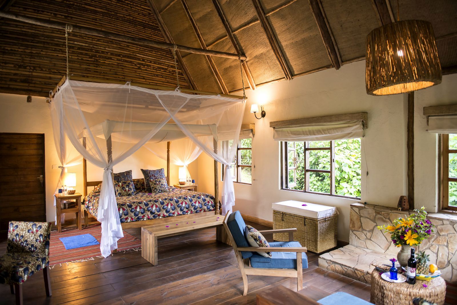 A bedroom with four poster bed and mosquito netting at Bwindi Lodge in Uganda.