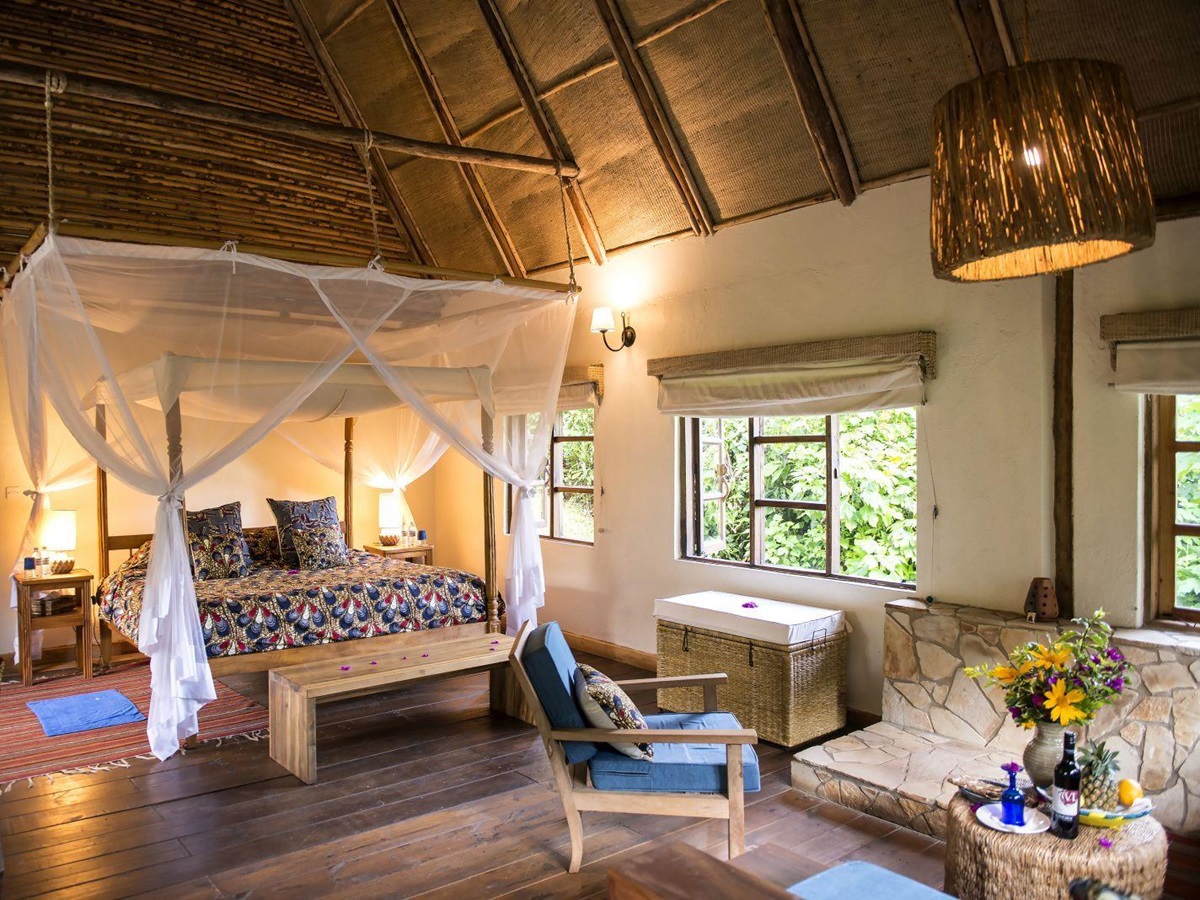 A bedroom with four poster bed and mosquito netting at Bwindi Lodge in Uganda.