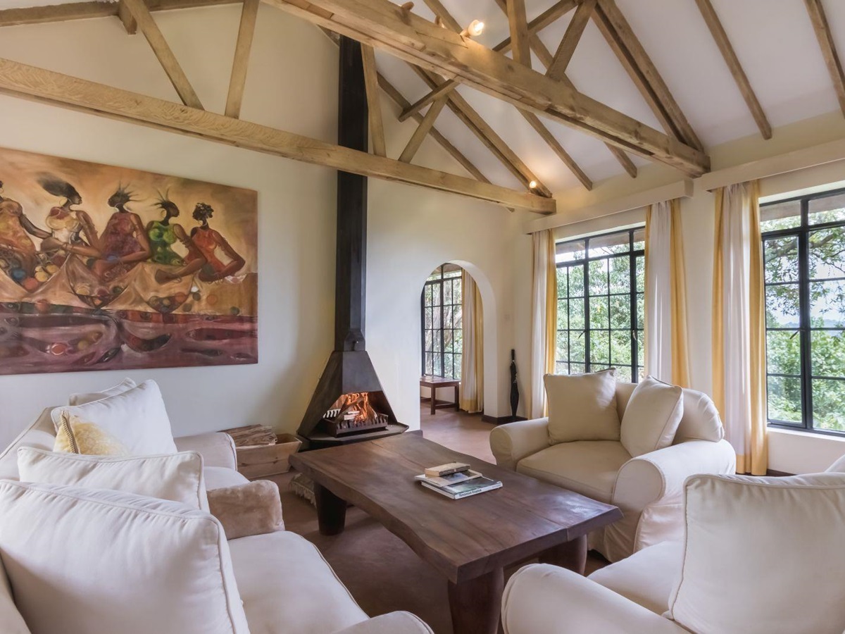 Living area with white comfy chairs and coffee table in a bedroom at Clouds Mountain Gorilla Lodge in Uganda