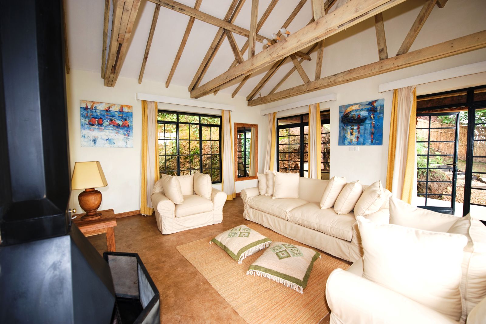 The lounge area with white sofas and chairs in a bedroom at  Clouds Mountain Gorilla Lodge in Uganda