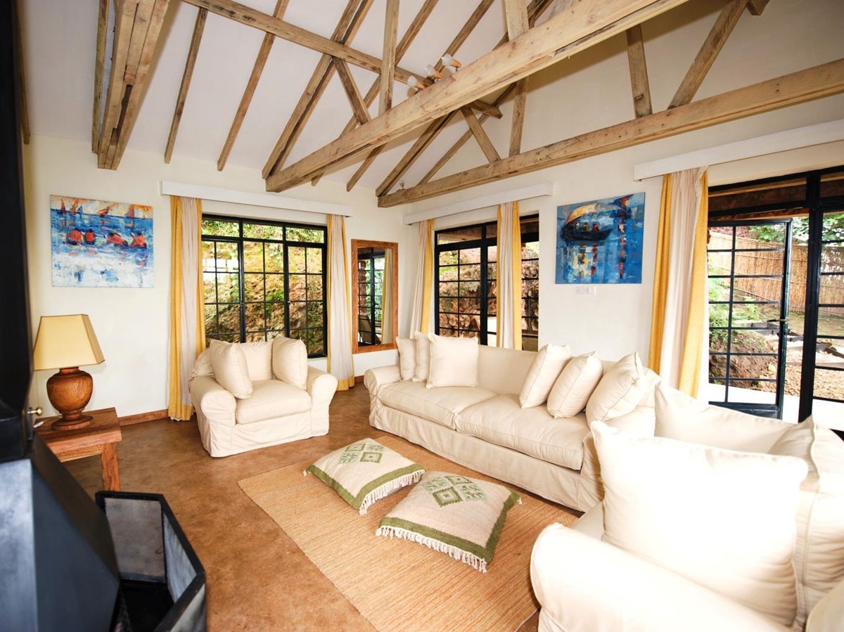 The lounge area with white sofas and chairs in a bedroom at Clouds Mountain Gorilla Lodge in Uganda