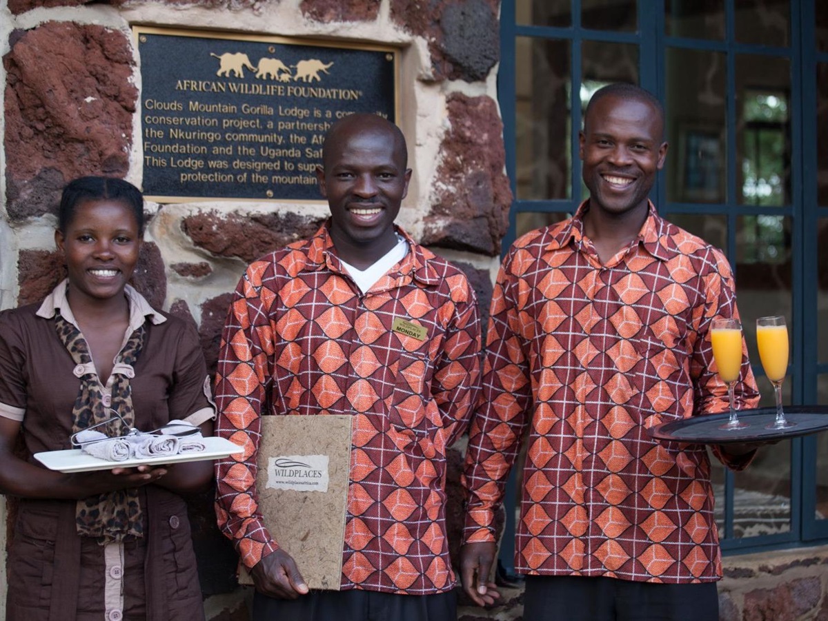 Three members of staff, one woman and two men, at Clouds Mountain Gorilla Lodge in Uganda