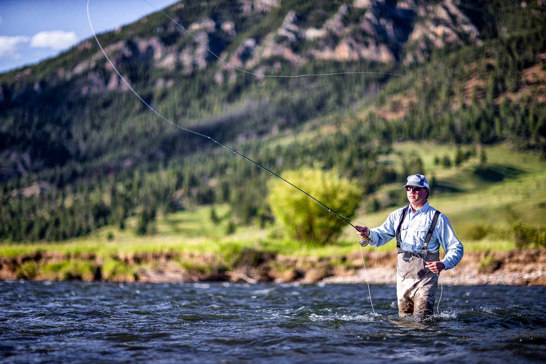 A man fishing in the river on the grounds of Lone Mountain Ranch in Montana