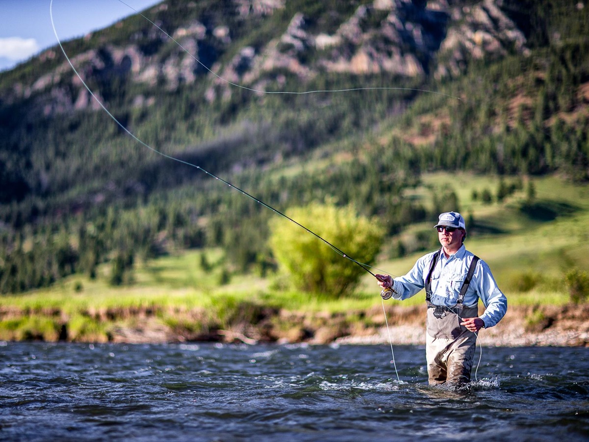 A man fishing in the river on the grounds of Lone Mountain Ranch in Montana