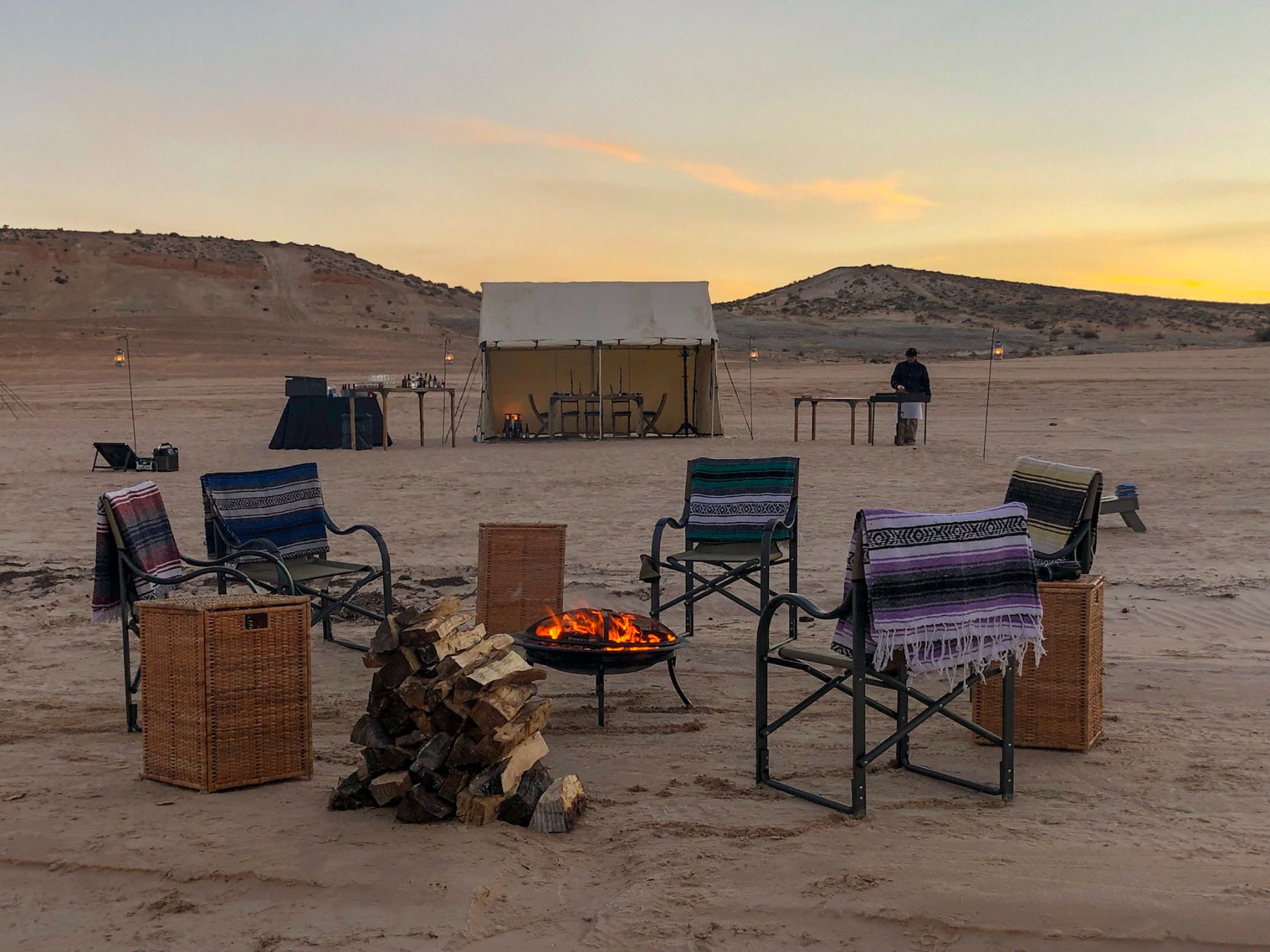 A campfire set up at dusk near Lake Powell as part of EXP Journeys luxury camps