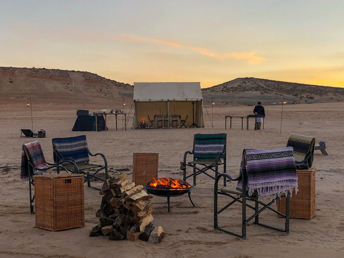 A campfire set up at dusk near Lake Powell as part of EXP Journeys luxury camps