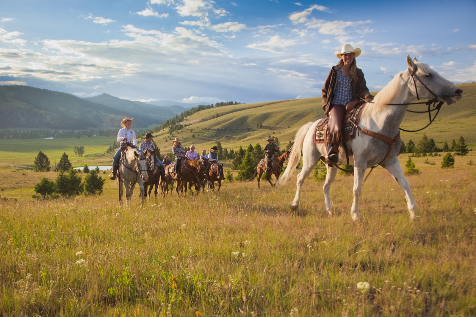 A group of riders with mountains in the background