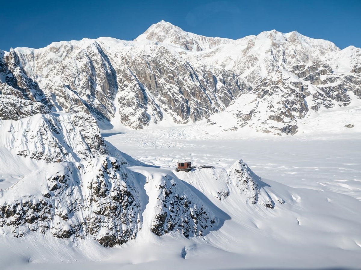 Dramatic snowy mountains with chalet in the centre