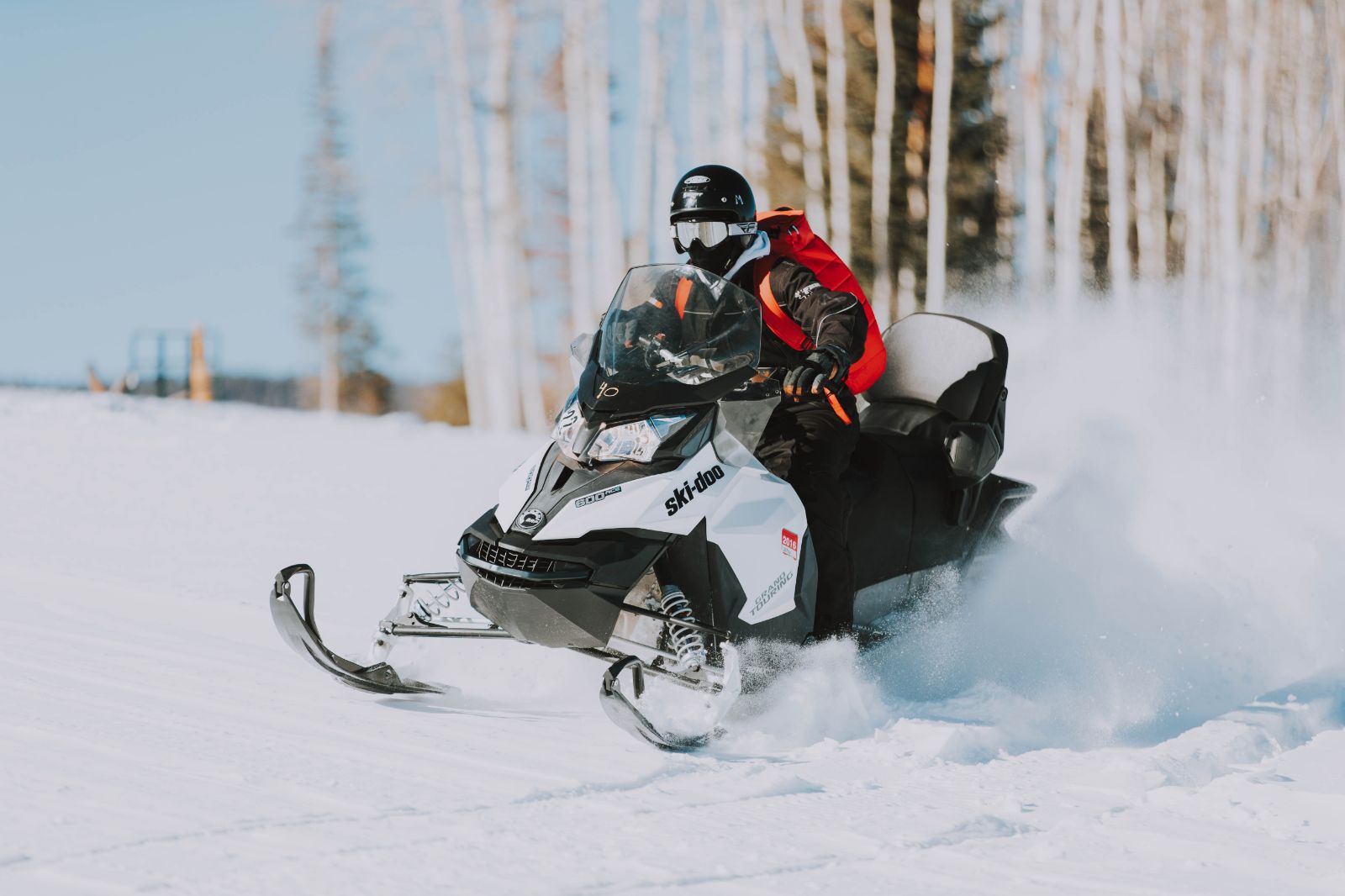 Person driving a snowmobile through the snow at luxury lodge The Lodge at Blue Sky