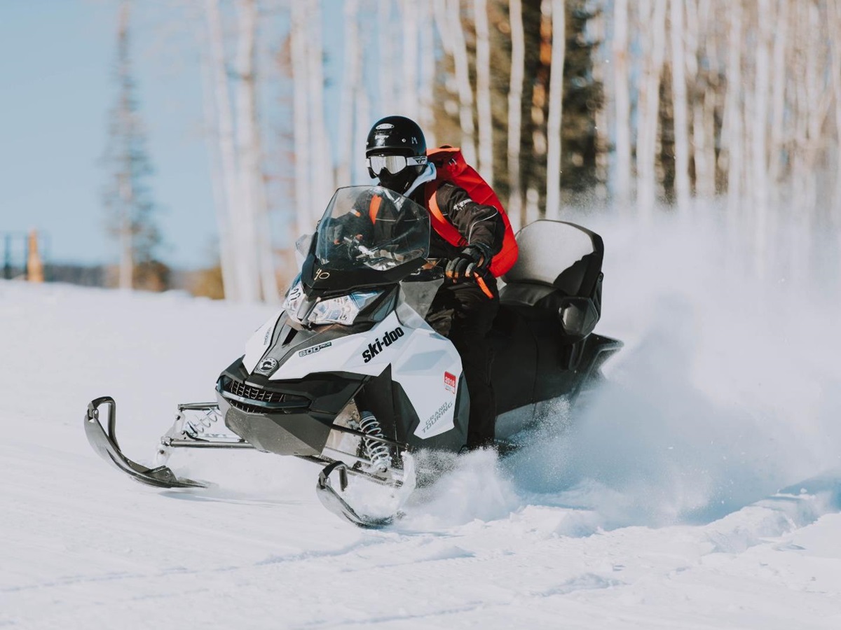 Person driving a snowmobile through the snow at luxury lodge The Lodge at Blue Sky