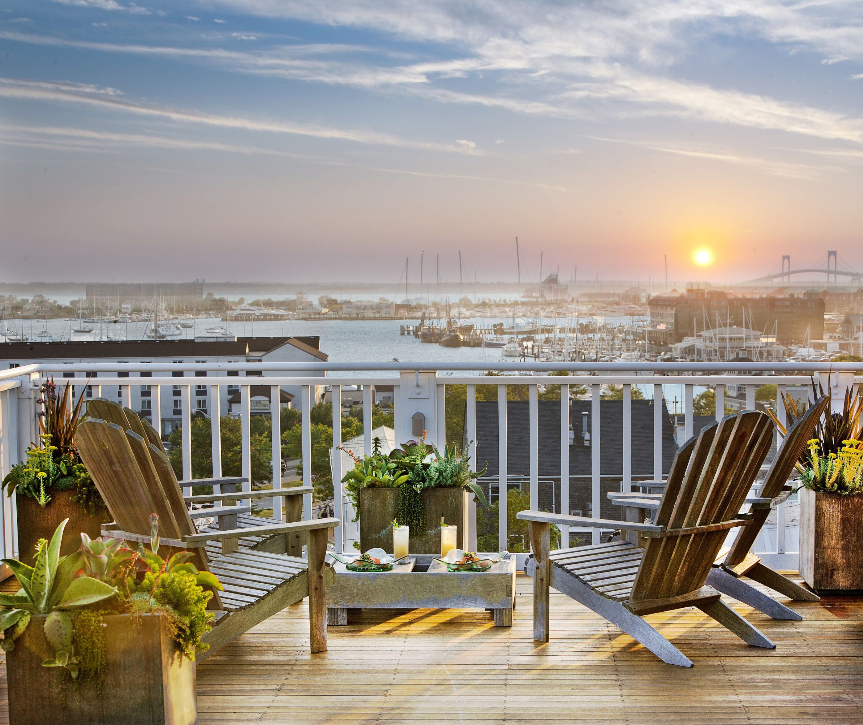 Sun loungers on a balcony viewing the sunset over Newport Harbor from Vanderbilt Grace, USA