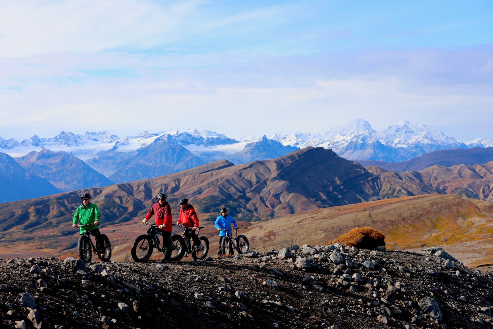 Group of cyclists on top of a hill with mountain views