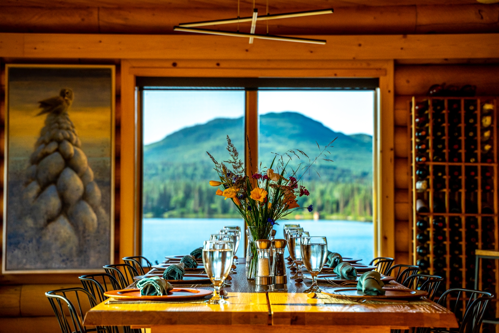 Dining table set for dinner with a window and views over a lake