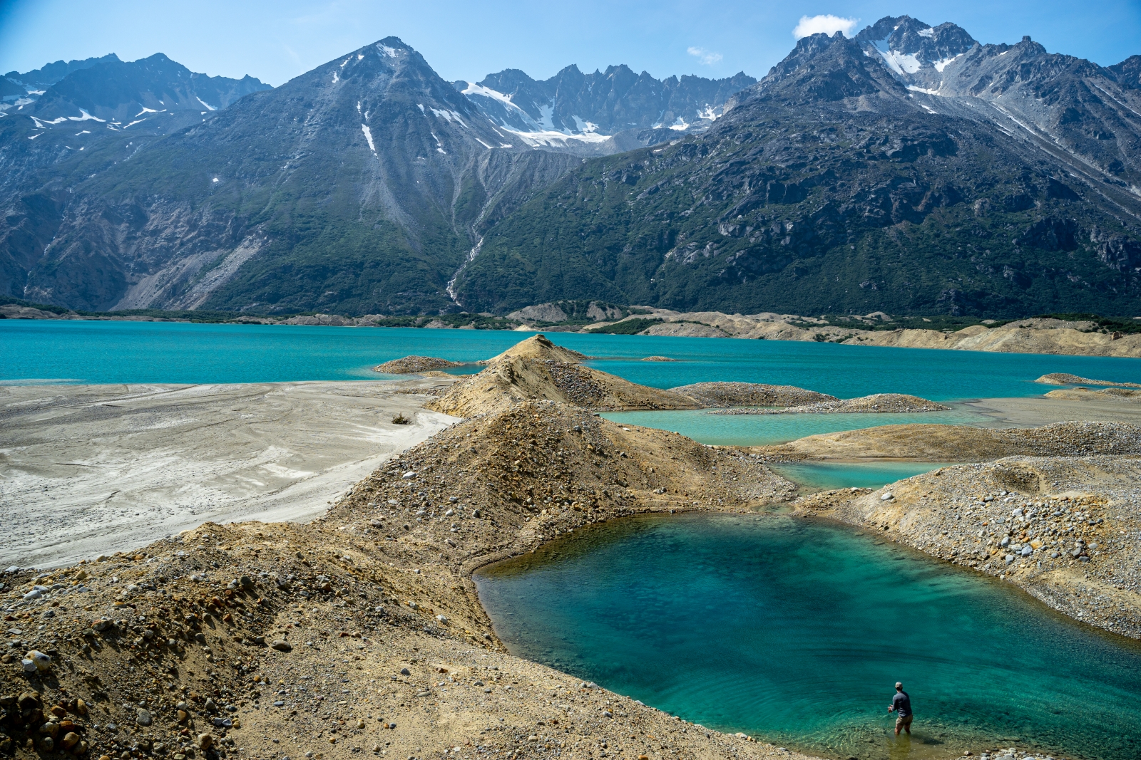 A large blue glacier with mountains in the background