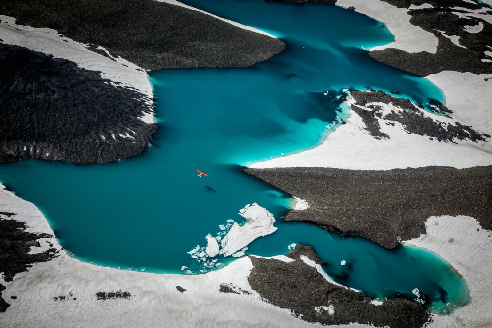 Plane flying over a lake near Ulitma Thule Lodge in Alaska's Wrangell-St Elias. National Park