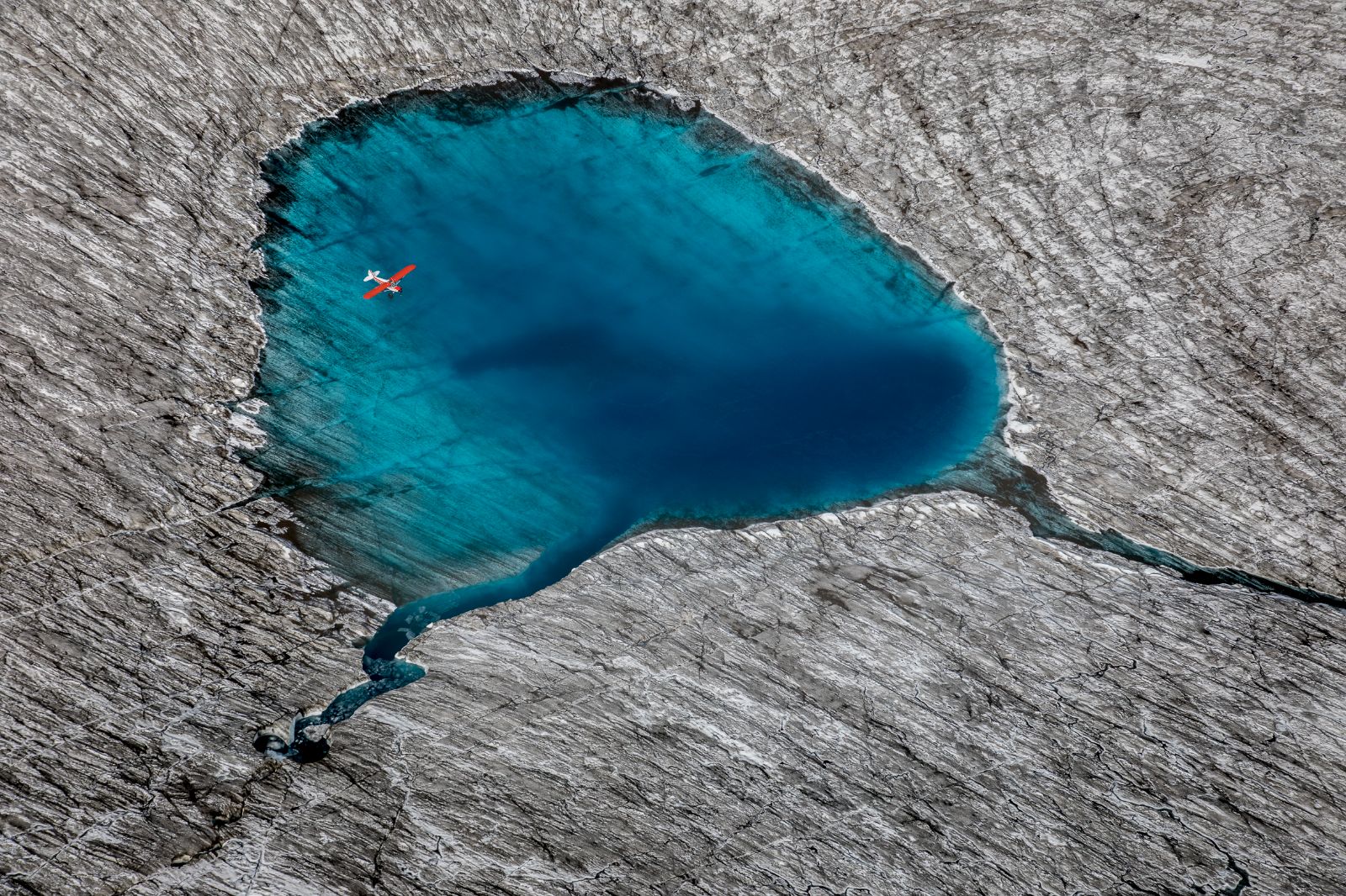 A plane flying over a small lake near Ulitma Thule Lodge in Alaska's Wrangell-St Elias. National Park