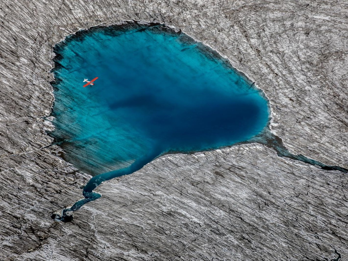 A plane flying over a small lake near Ulitma Thule Lodge in Alaska's Wrangell-St Elias. National Park
