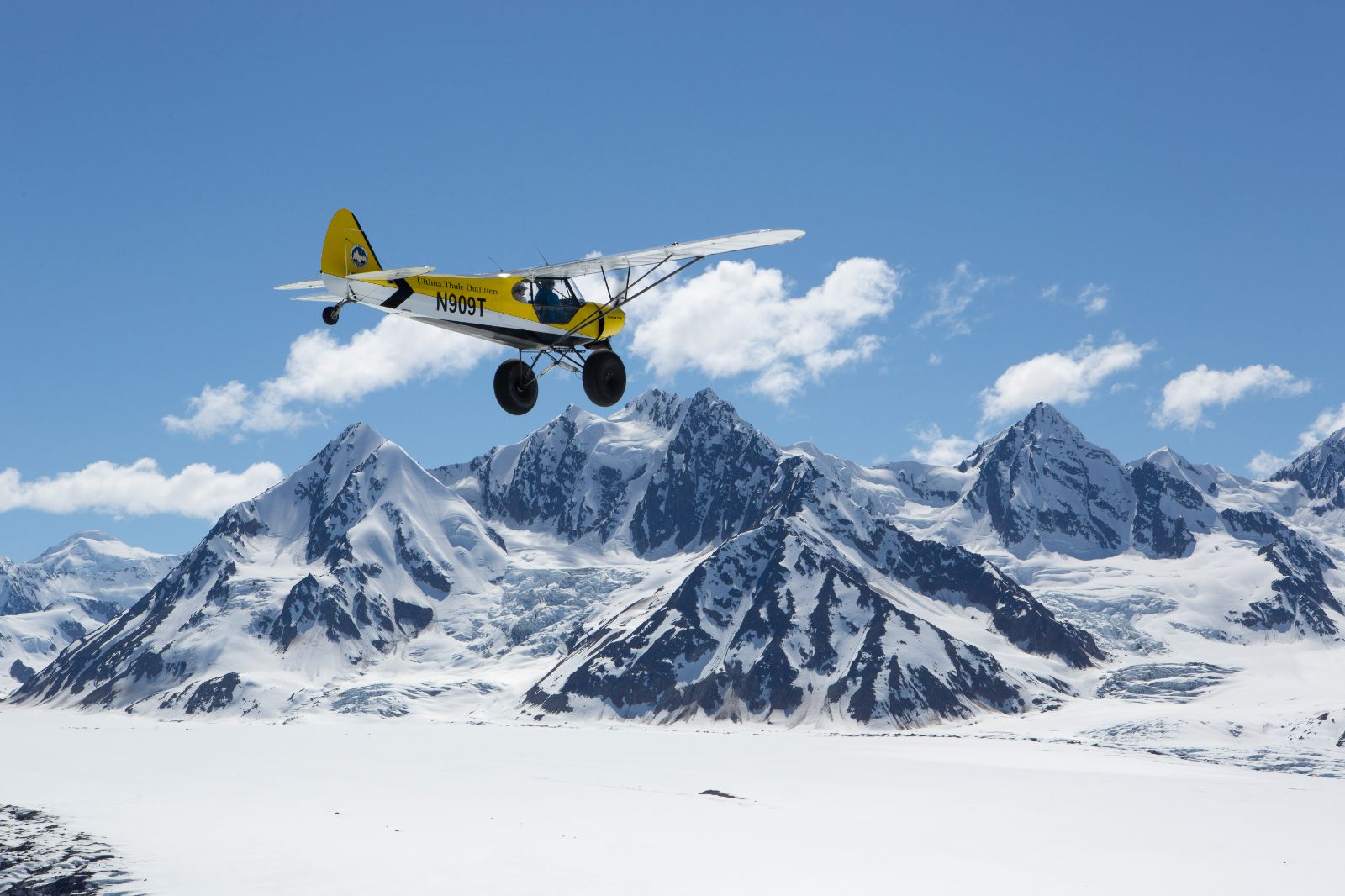 Plane flying through mountains near Ulitma Thule Lodge in Alaska's Wrangell-St Elias. National Park
