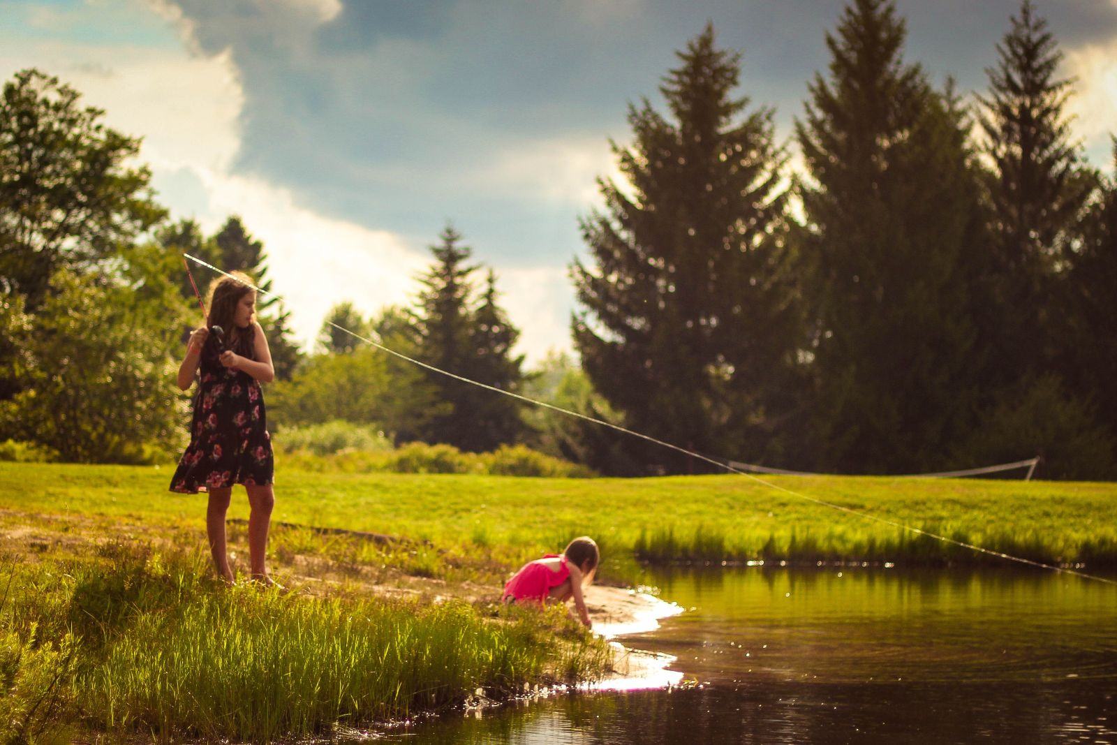Young girls fishing by a lake in the USA