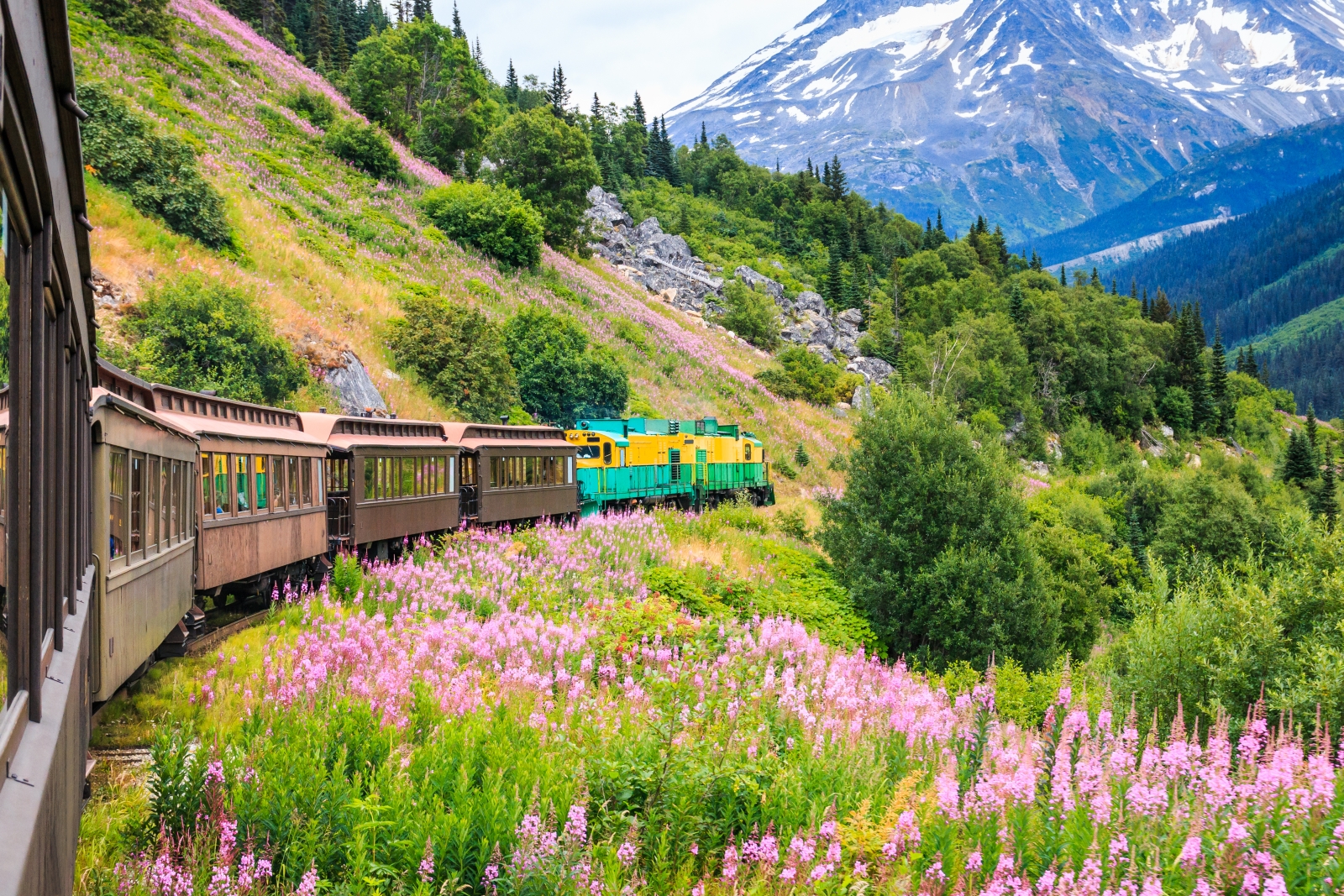A carriage train winds through the mountains