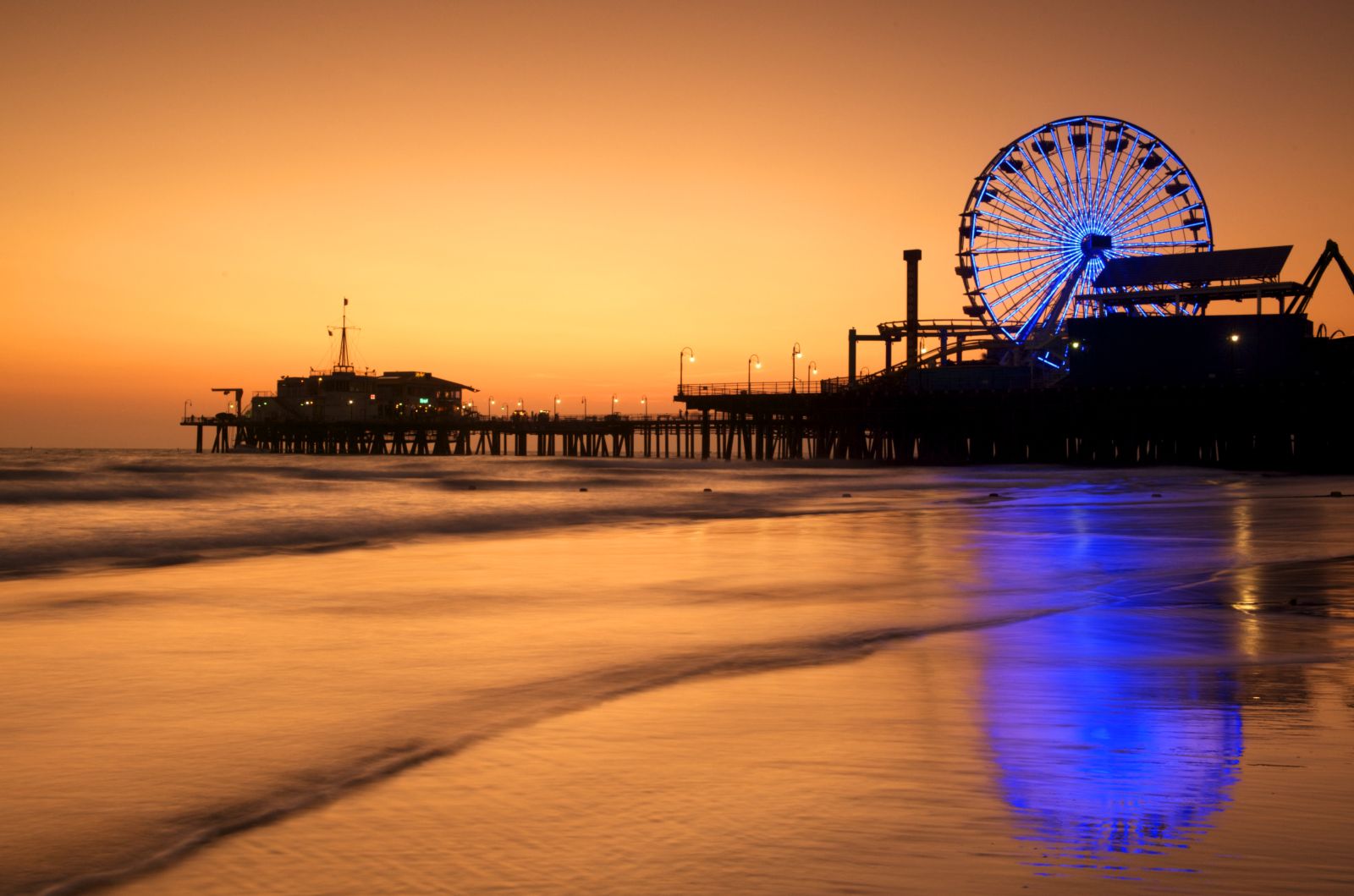 Reflection of Santa Monica Pier on the beach at sunset
