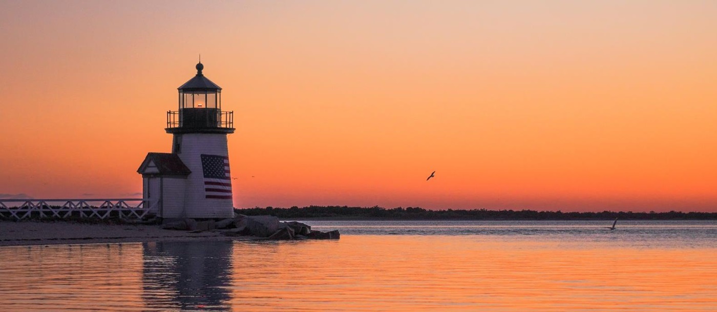Lighthouse out at sea at with the sunset hues  