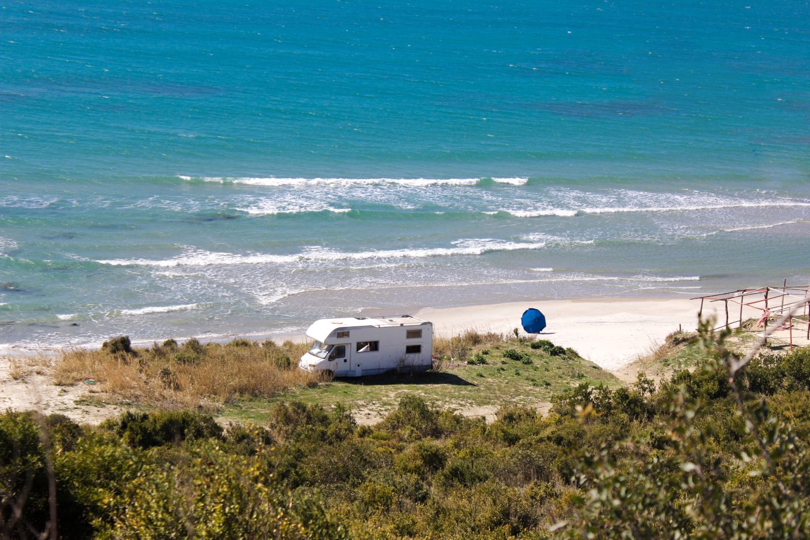 An RV parked in a beautiful coastal location facing the beach