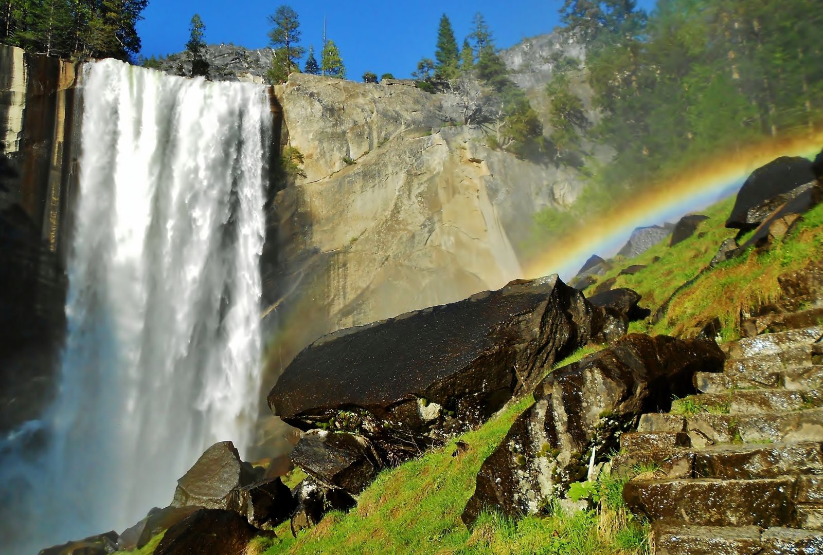 Waterfall and rainbow on a walking trail in Yosemite National Park, USA