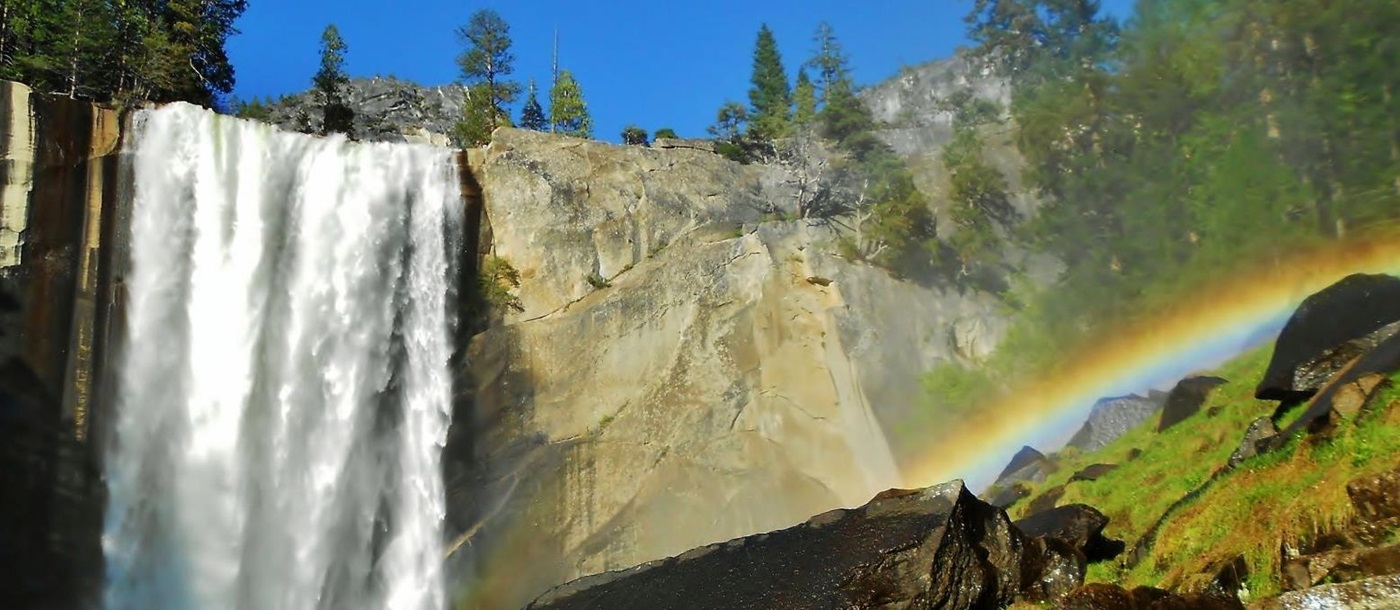 Waterfall and rainbow on a walking trail in Yosemite National Park USA