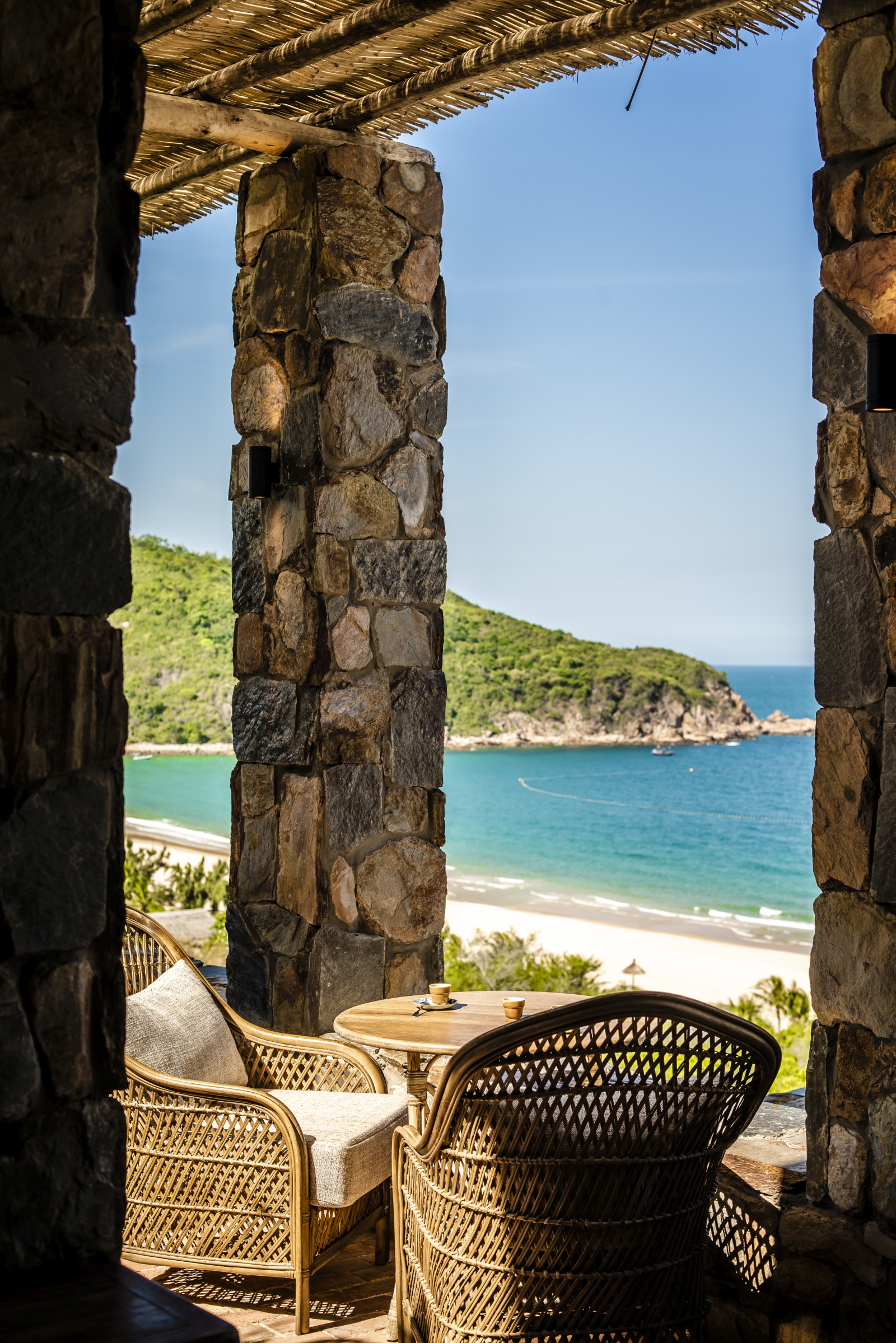 Chairs on a terrace overlooking the bay at luxury resort Zannier Bai San Ho in Vietnam