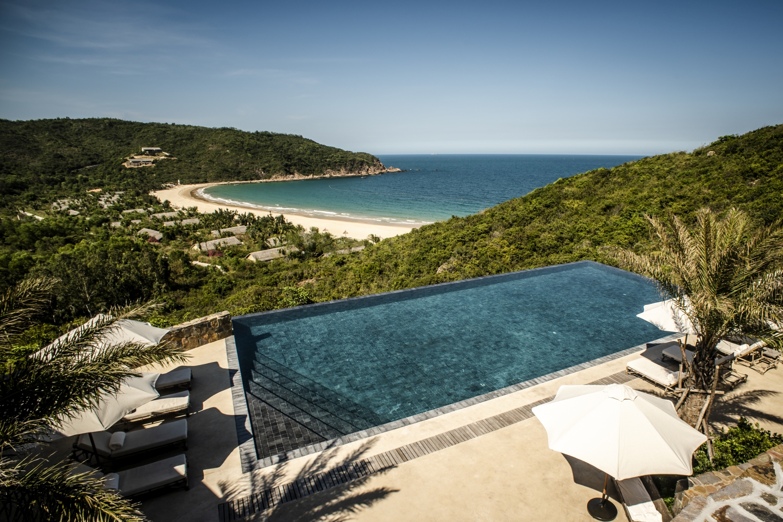 Main pool with loungers and views over the bay at luxury resort Zannier Bai San Ho in Vietnam