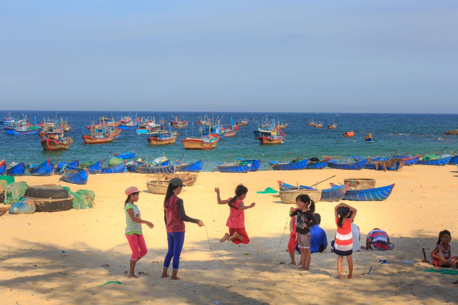 Local children playing on a golden sand beach in Vietnam