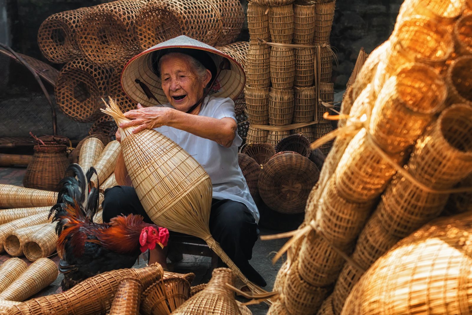 Smiling Vietnamese lady weaving baskets