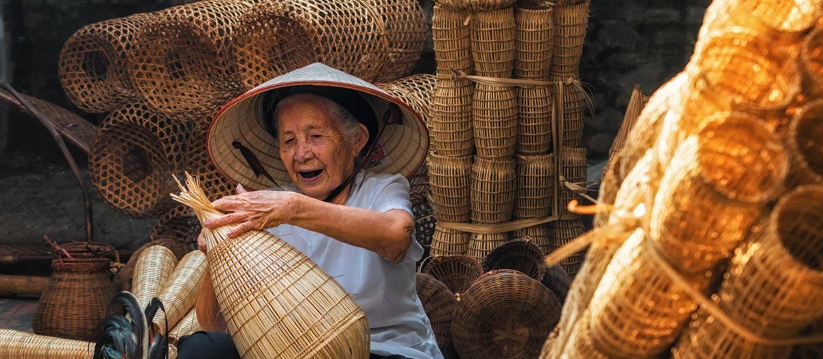 Smiling Vietnamese lady weaving baskets