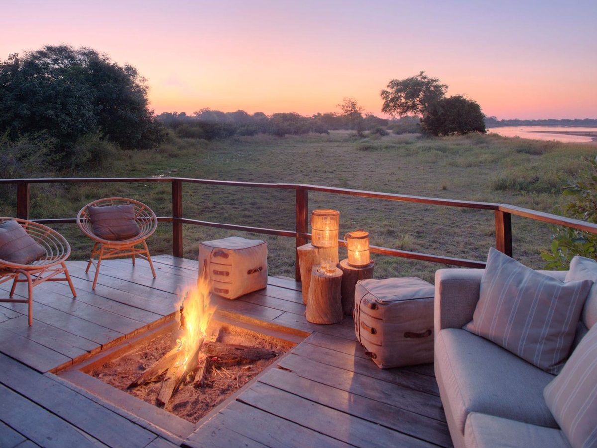 Comfortable campfire deck with couch and chairs overlooking the river at luxury safari camp Kakuli Bush Camp in Zambia's South Luangwa National Park